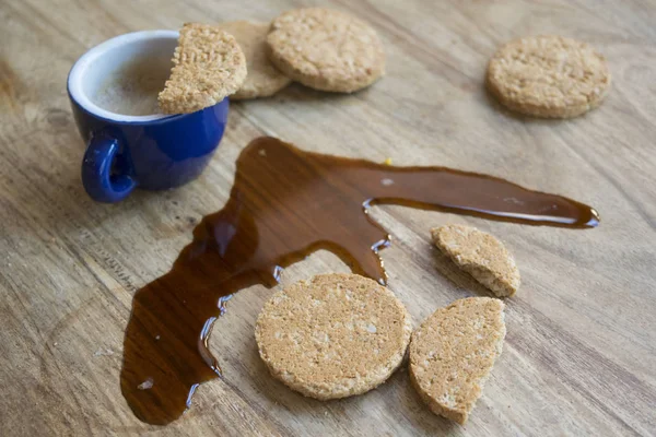 Kex och espressokaffe spillt på bordet — Stockfoto