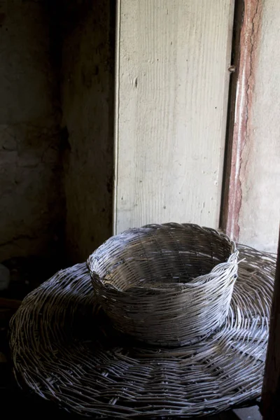 Old wicker basket illumined between a window — Stock Photo, Image