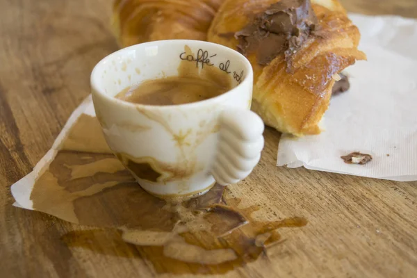Restjes van espressokoffie en chocolade hoorn — Stockfoto