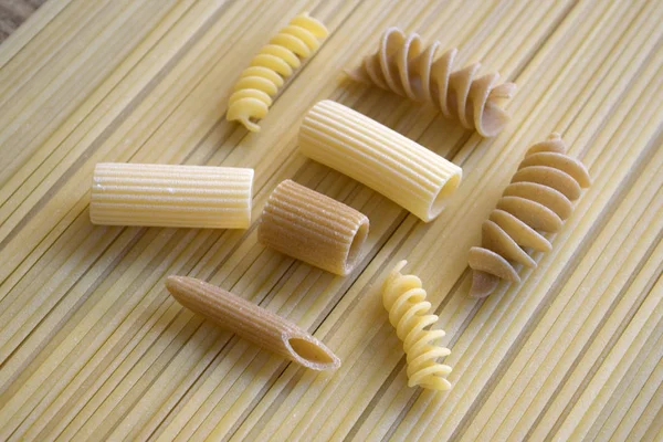 Verschillende soort pasta op achtergrond van spaghetti — Stockfoto