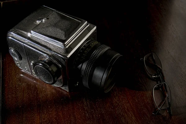 Old camera and a pair of specs — Stock Photo, Image