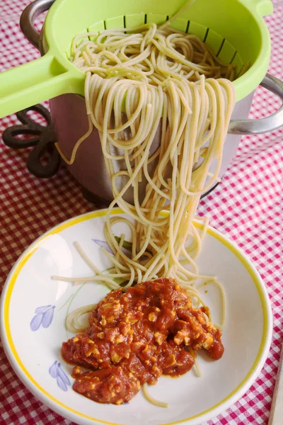 Спагетті стирчать з друшляка і томатного соусу — стокове фото