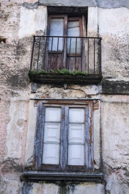 Terk edilmiş bir binanın ön cephesinde harap olmuş pencereler.