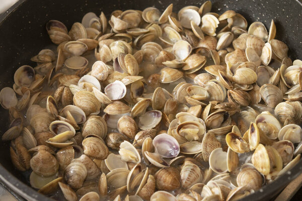 lupini clams cooking in pan to season the pasta