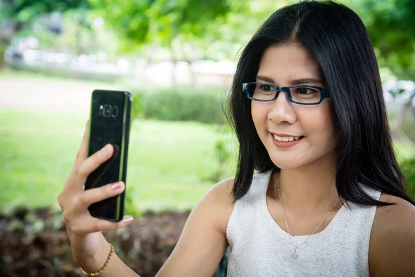 Szczęśliwa młoda kobieta trzymając telefon komórkowy selfie. — Zdjęcie stockowe