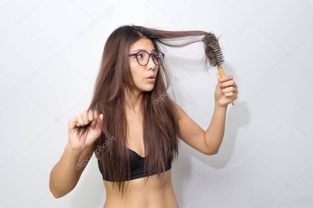 Woman loosing hair holding comb. Young girl losing hair problem, falling hair on brush. Treated healthy medical treatment hair lost concept.