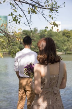 Çiçekler birine vermeye hazır tutan kadın. Karı sürpriz koca Sevgililer günü kavramı.