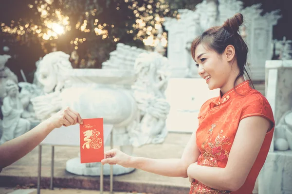 Portrait beautiful young girl. Chinese woman wearing traditional costume during Chinese New Year.Happy lady on culture season period. Female with China traditional dressing red cheongsam.