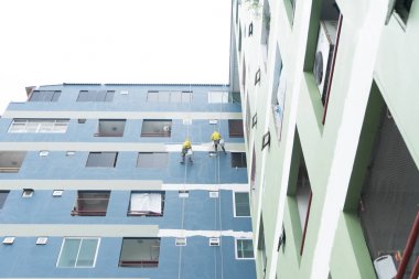 roll üzerine asılı ressamlar boyama renk yüksek building.safety İnşaat Asansör halat kemer City ile wall.facade Oluşturucu işçisi ile rulo fırça, bina.
