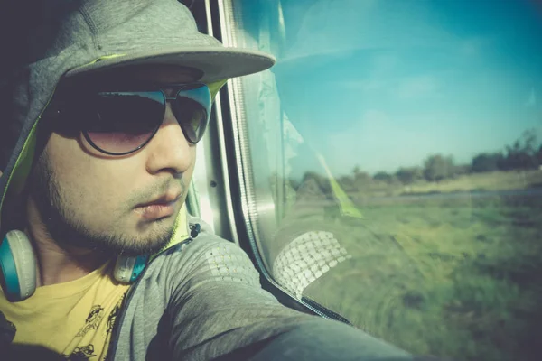 Portrait man in a train carriage. Handsome Asian man looking through train window with copy space