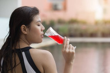 Bikini kız tatil yaz sezonu havuz kenar havuz kenarında kırmızı şarap ile dinlenme. Arkadan görünüm