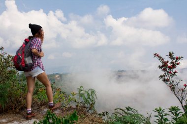 En iyi dağ zirvesinde bulutların üstünde duran, vadi manzaralı zevk spor hippi kız backpacker