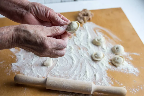 Sculpting of traditional Russian meat dumplings with minced meat — Stock Photo, Image