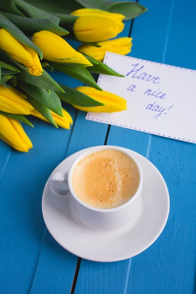 Ramo de tulipanes amarillos y una taza de café — Foto de Stock