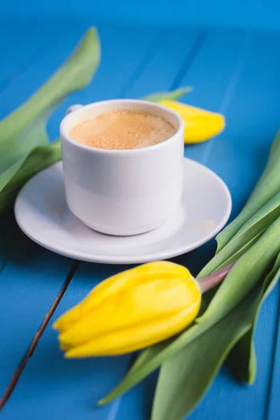 Bukiet żółtych tulipanów i filiżanka kawy — Zdjęcie stockowe