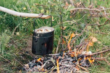 Bir kamp açık ateşte çorba demir pot aşçılar