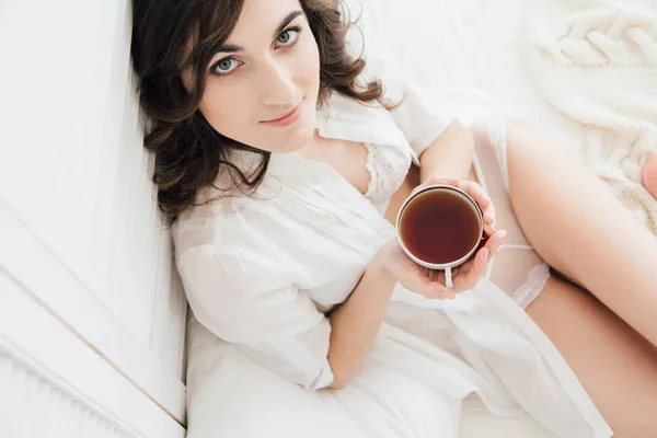 Dziewczyna, picie herbaty w łóżku rano — Zdjęcie stockowe