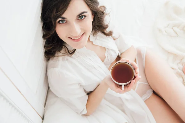 Chica bebiendo té en la cama por la mañana — Foto de Stock