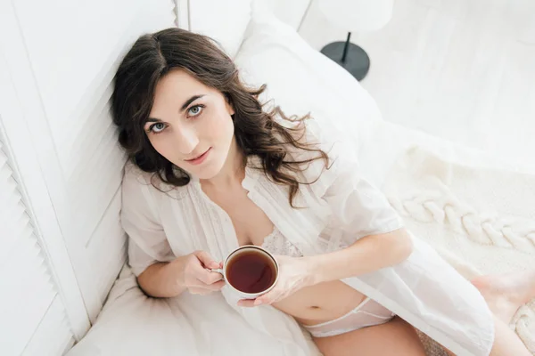 Chica bebiendo té en la cama por la mañana — Foto de Stock