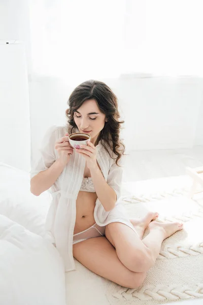 Дівчина п'є чай в ліжку вранці — стокове фото
