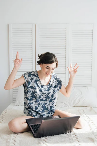 Meisje kijkend naar de laptop op het bed — Stockfoto