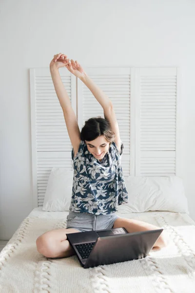 A lány nézi a laptop az ágyon — Stock Fotó