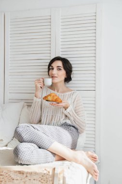 Kız yatakta kahve ve çörek içme 