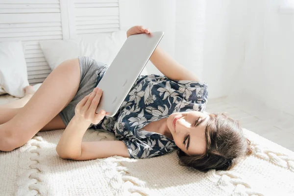 Meisje kijkend naar tablet in bed — Stockfoto