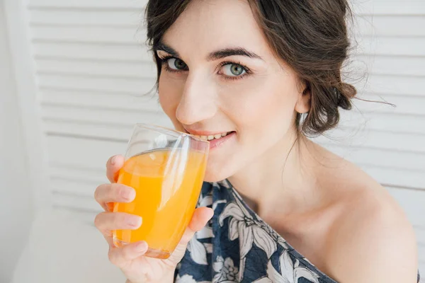 Chica bebiendo jugo de naranja en el desayuno en la cama — Foto de Stock