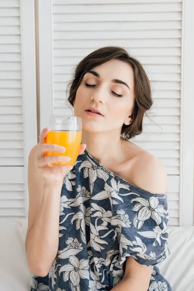 Mädchen trinkt Orangensaft beim Frühstück im Bett — Stockfoto