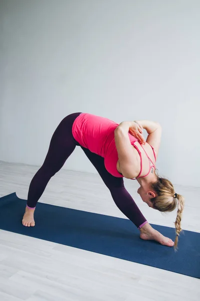 Wanita muda di ruangan putih melakukan latihan yoga  . — Stok Foto