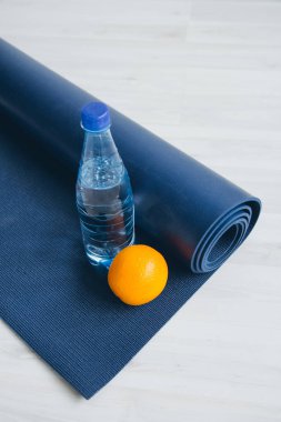 Su şişesi, portakal ve yoga Mat. 