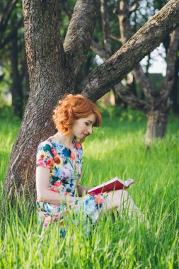 Güzel kadın bahar bahçe bir kitap okuma