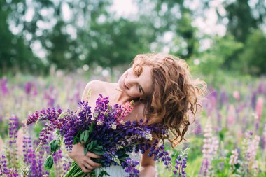 Lupine alanında bir buket ile kız