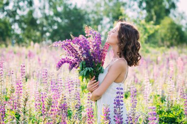 Lupine alanında bir buket ile kız