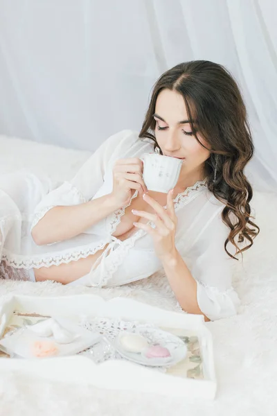 Wanita muda cantik berpakaian putih bubur di pagi hari — Stok Foto