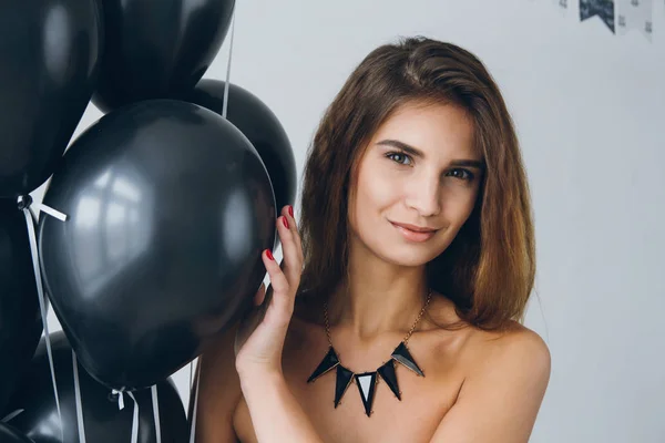 Menina em um vestido preto com balões pretos — Fotografia de Stock