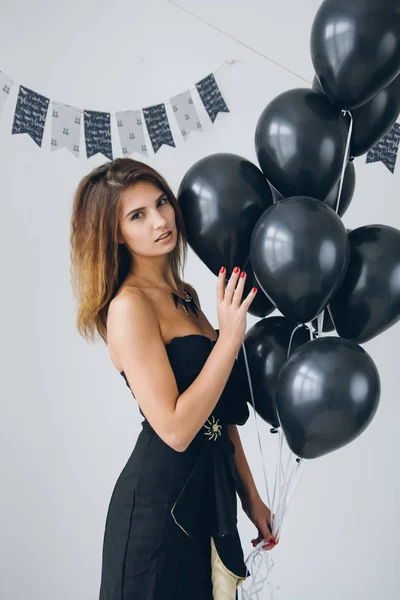 Девушка в чёрном платье с чёрными шариками — стоковое фото
