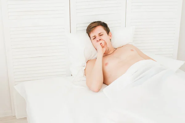 Young man wakes up in the morning — Stock Photo, Image