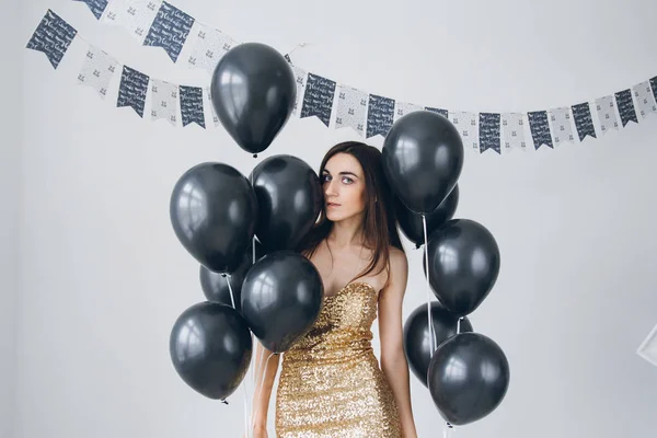 Dziewczyna w złota sukienka z czarne balony — Zdjęcie stockowe