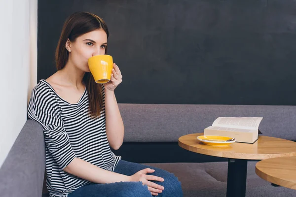 Девушка пьет кофе в кофейне — стоковое фото