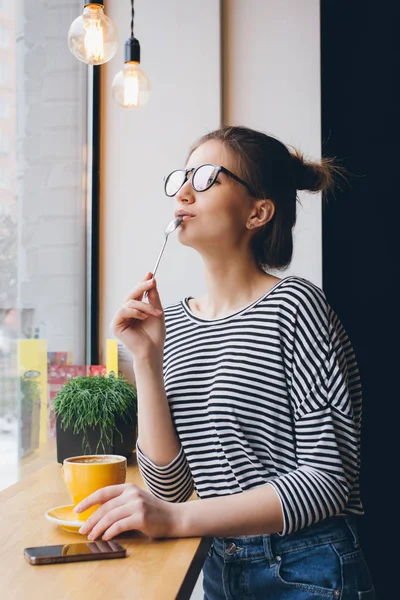 Девушка в очках пьет кофе — стоковое фото