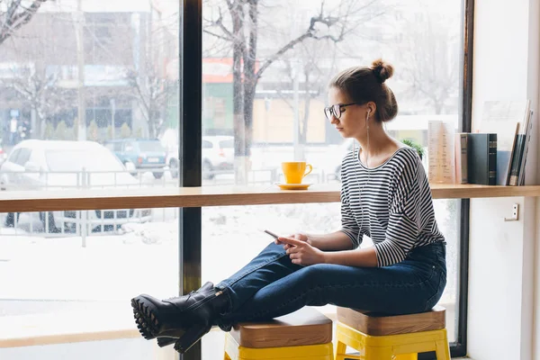 Meisje luisteren naar muziek op uw smartphone en koffie drinken — Stockfoto