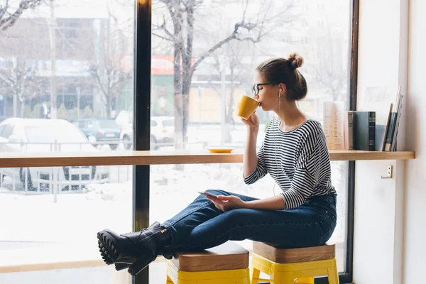 Menina ouvindo música em seu smartphone e beber café — Fotografia de Stock