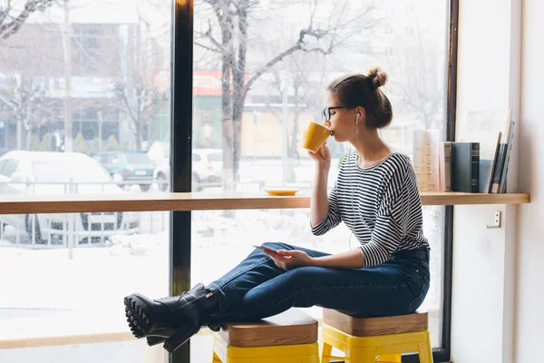 Meisje luisteren naar muziek op uw smartphone en koffie drinken — Stockfoto