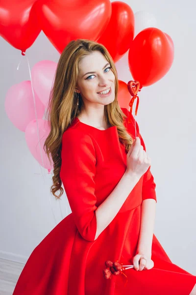 Dziewczyna w czerwonej sukience z balony w kształcie serca — Zdjęcie stockowe