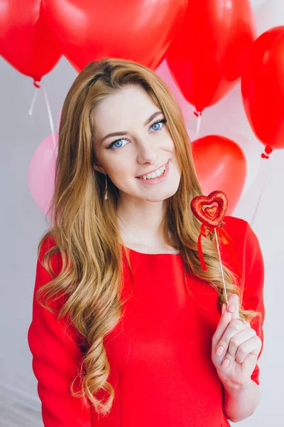 Chica en vestido rojo con globos en forma de corazón — Foto de Stock