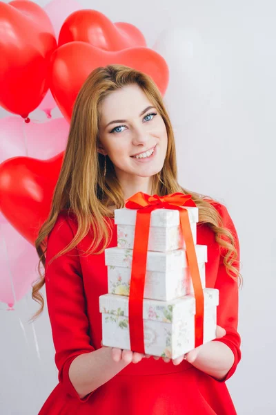 Dziewczyna w czerwonej sukience posiada pola prezenty — Zdjęcie stockowe