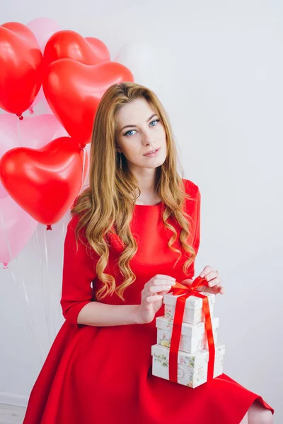 Ragazza in abito rosso contiene scatole con regali — Foto Stock