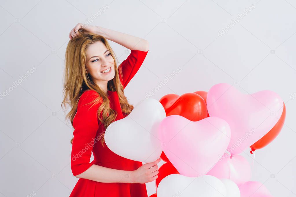 Girl in red dress with balloons in the shape of a heart